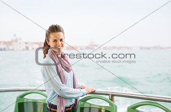Smiling woman tourist standing on a boat in Venice