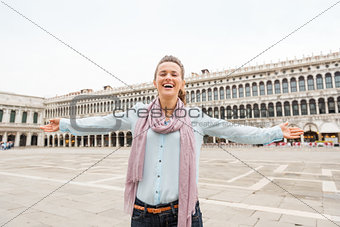 Happy woman tourist rejoicing on St. Mark's Square