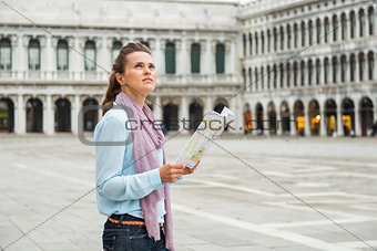 Woman in profile holding map looking up on St. Mark's Square