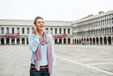 Woman tourist laughing on mobile in St. Mark's Square