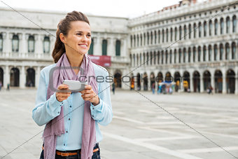 Woman looking up from her device while on St. Mark's Square