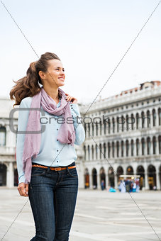 Happy woman tourist walking through St. Mark's Square