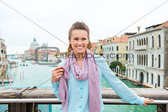 Smiling woman holding scarf standing on Bridge