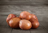 Fresh potatoes on wooden board