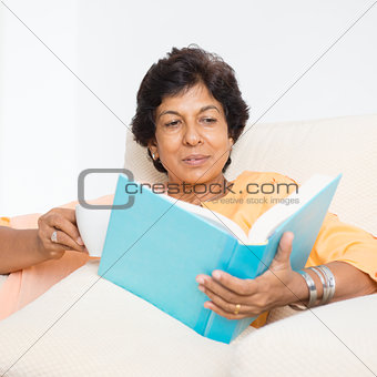 Indian mature woman reading book