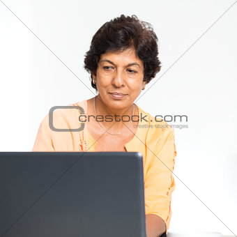 Indian mature woman using laptop computer