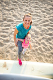 Happy young mother and daughter in fitness gear on the beach