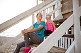 Mother and daughter sitting and talking on beach-house steps