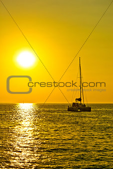 Catamaran sailboat at golden sunset