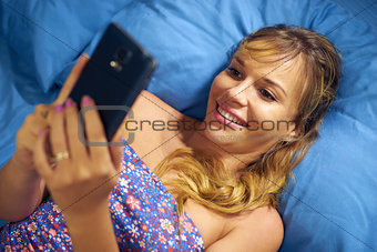 Girl In Bed Reading Love Phone Message From Boyfriend