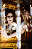 Gothic fashion: mysterious beautiful young woman looking into mirror
