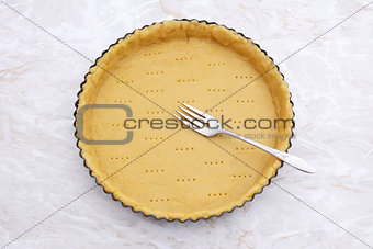 Fork rests in a pricked pastry pie crust