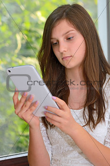 Young girl reading information on a tablet computer
