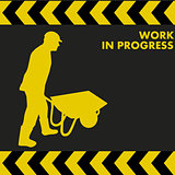 WORK IN PROGRESS sign with worker carries a wheelbarrow