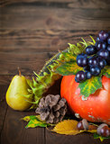 Autumnal still life with pumpkin and grapes on wooden board