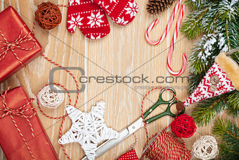 Christmas presents wrapping and snow fir tree over wooden table 