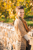Portrait of smiling elegant brunette woman in autumn park