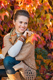 Portrait of pensive woman with leafs in front of autumn foliage
