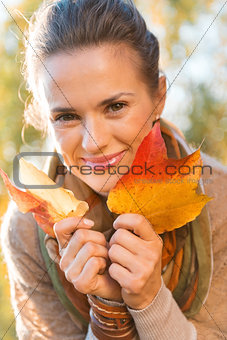 Portrait of smiling relaxed woman with autumn leafs