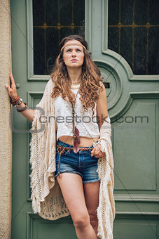 Portrait of young boho chic standing outdoors against door