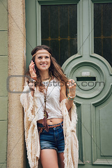 Portrait of happy young trendy hipster woman talking cell phone