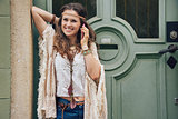 Happy woman wearing bohemian style clothes talking cell phone