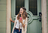 Happy trendy hipster woman with mobile phone standing outdoors