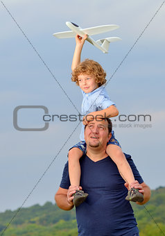 Father carrying son and his plane 