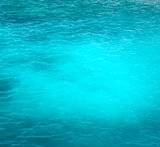 Background of a bright turquoise ocean water with gentle ripples