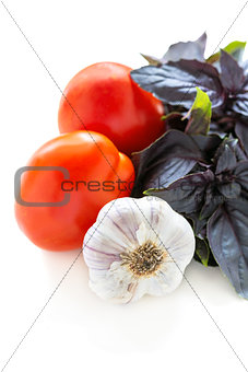 Purple basil, tomatoes and garlic closeup.