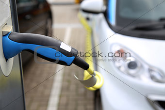 Electric car being charged at the station, close up of the power