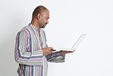 Profile view Indian man using computer 