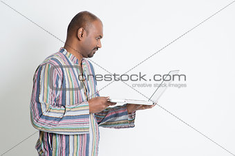 Profile view Indian man using computer 