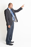 Side view mature Indian businessman pointing