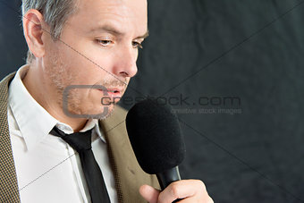 Serious Man Speaks Into Microphone