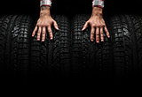 Men's hands on a car tires, studio shot