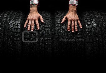 Men's hands on a car tires, studio shot