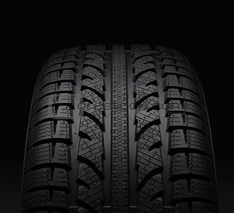 Close-up of car tire over black background