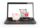 Shopping cart and piggy bank on laptop