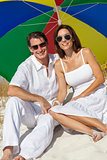 Man & Woman Couple Under Multi Colored Umbrella on Beach