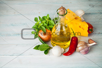 Olive oil with spices and vegetables on wooden board
