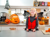 Happy halloween dressed girl in decorated kitchen