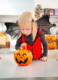 Halloween dressed girl with pumpkin bucket full of candy