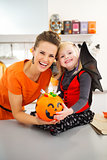 Portrait of halloween dressed girl with mother and candy