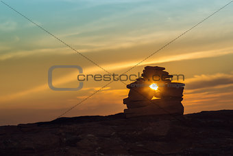 Close-up of Inukshuk  stones on ocean shore at sunset