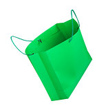 green shopping bag falling through the air on an isolated white 