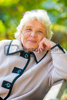 Smiling elderly pensioner rest on the nature in the park