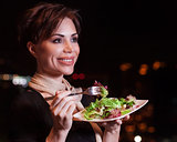 Happy woman eating salad