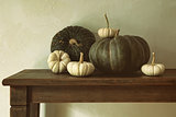 Green pumpkins and small gourds on table 
