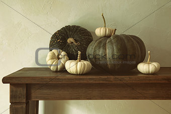 Green pumpkins and small gourds on table 